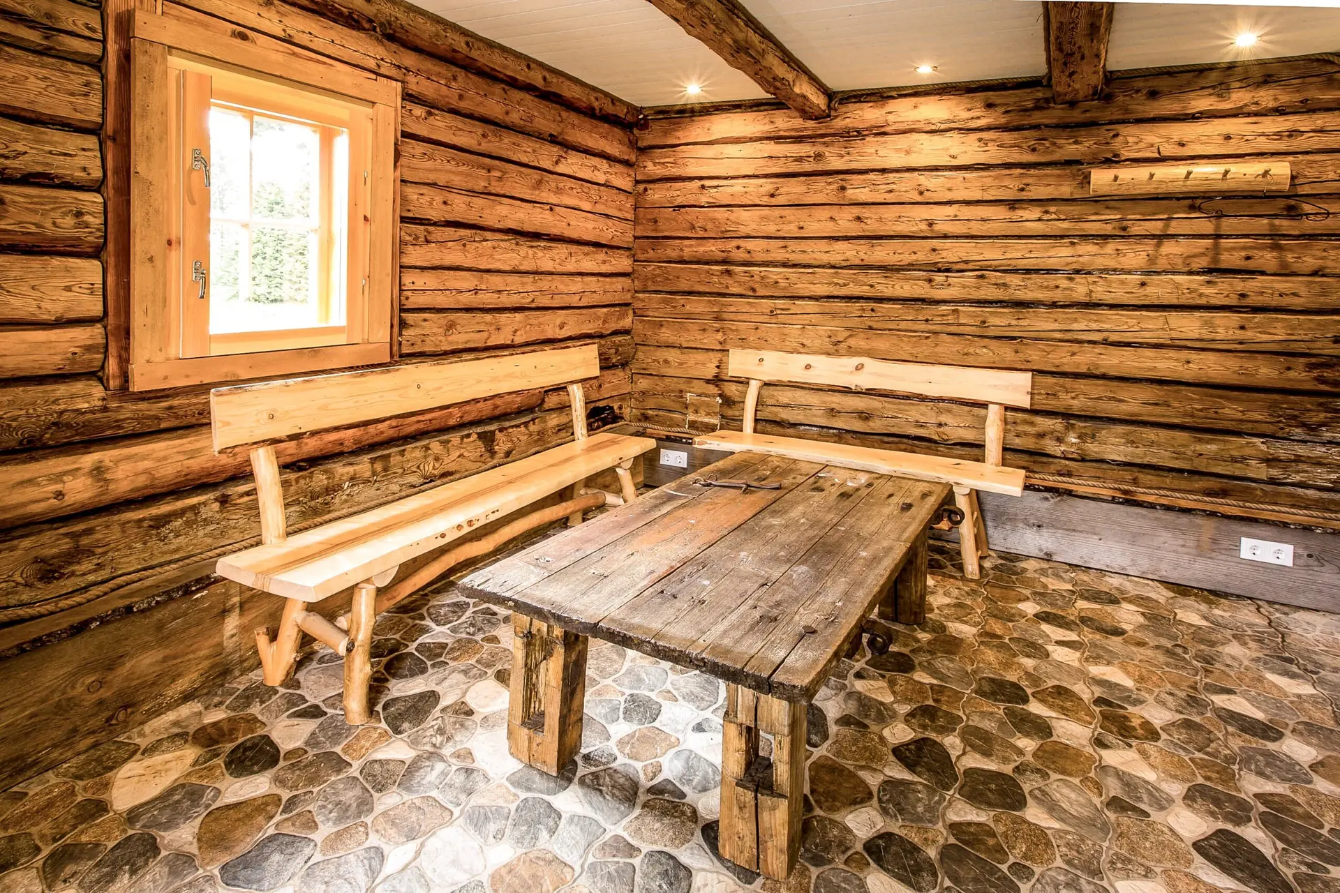 Saunamaja puhkeruum puulaua ja pinkidega